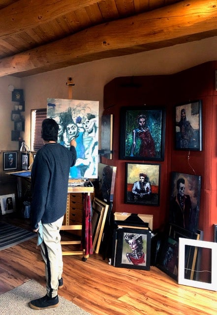 a man standing in front of a painting of a man
