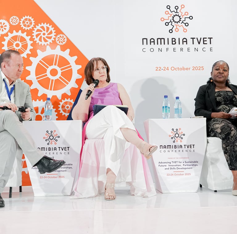 Three people on stage at a conference