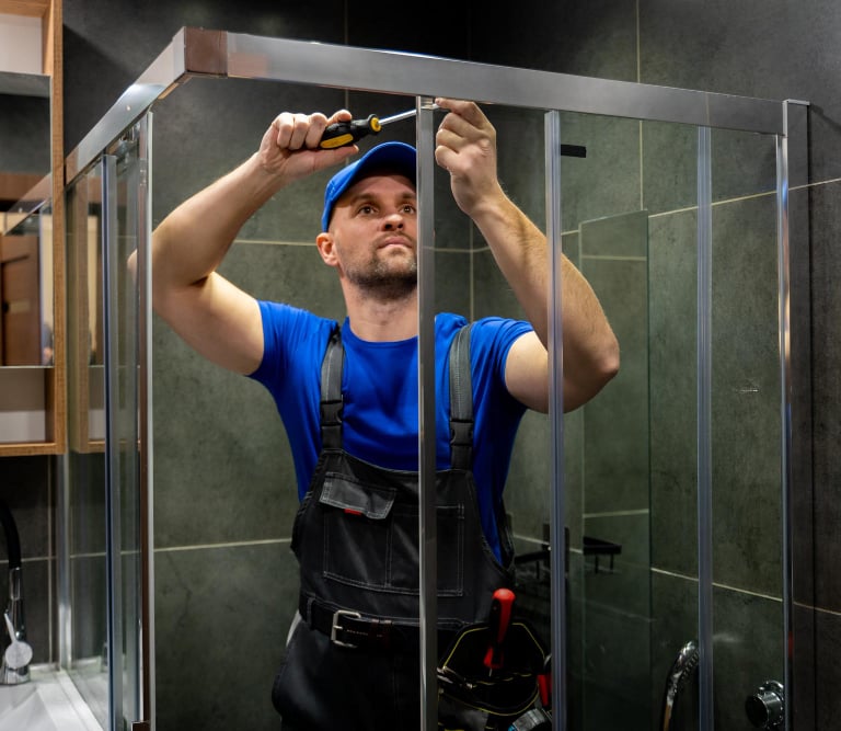 Plumer fixing a shower door in Auckland