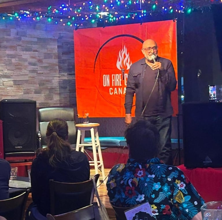 A stand-up comedian performs live on stage at On Fire Comedy Canada with a microphone and audience.