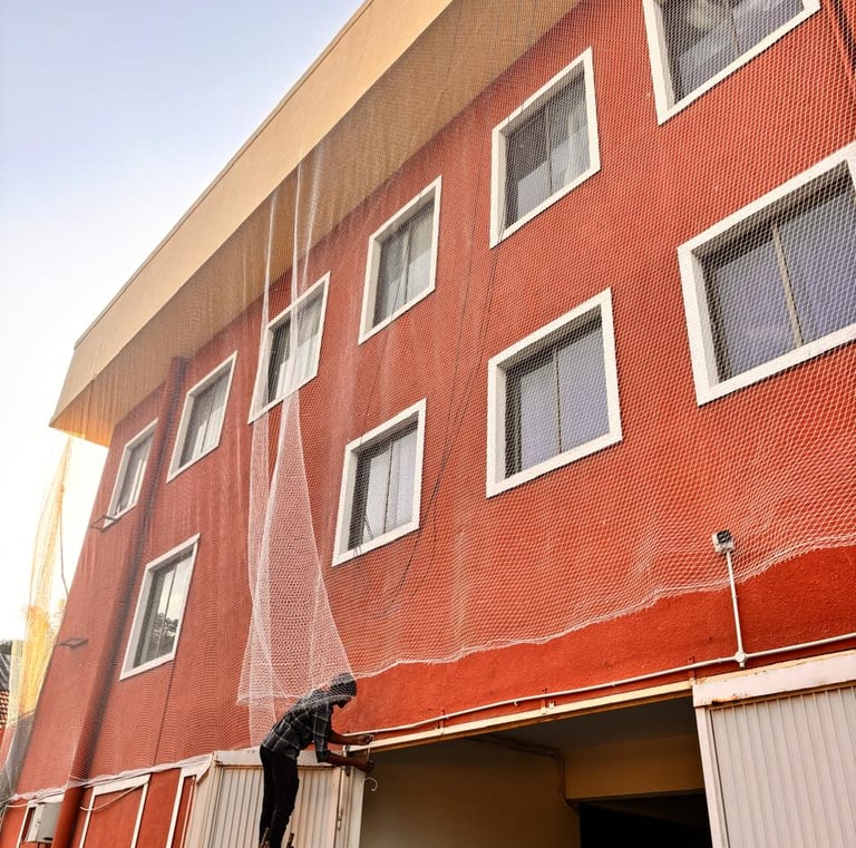 Pigeon net fixed on apartment balcony using stainless steel hooks