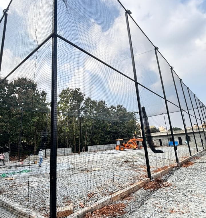 Wide shot of a rooftop safety net installation protecting a busy construction site in Ahmedabad