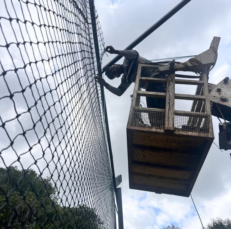 Technicians carefully installing a safety net along a high-rise building facade in Chennai