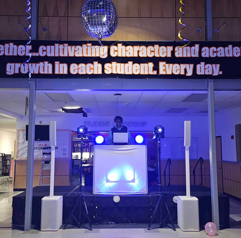 DJ Aaron Harris performing on stage at Silverton High School in the commons area