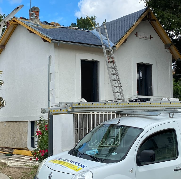 Fourgon d'un entrepreneur en toiture professionnel garé devant une maison en cours de réparation d'u