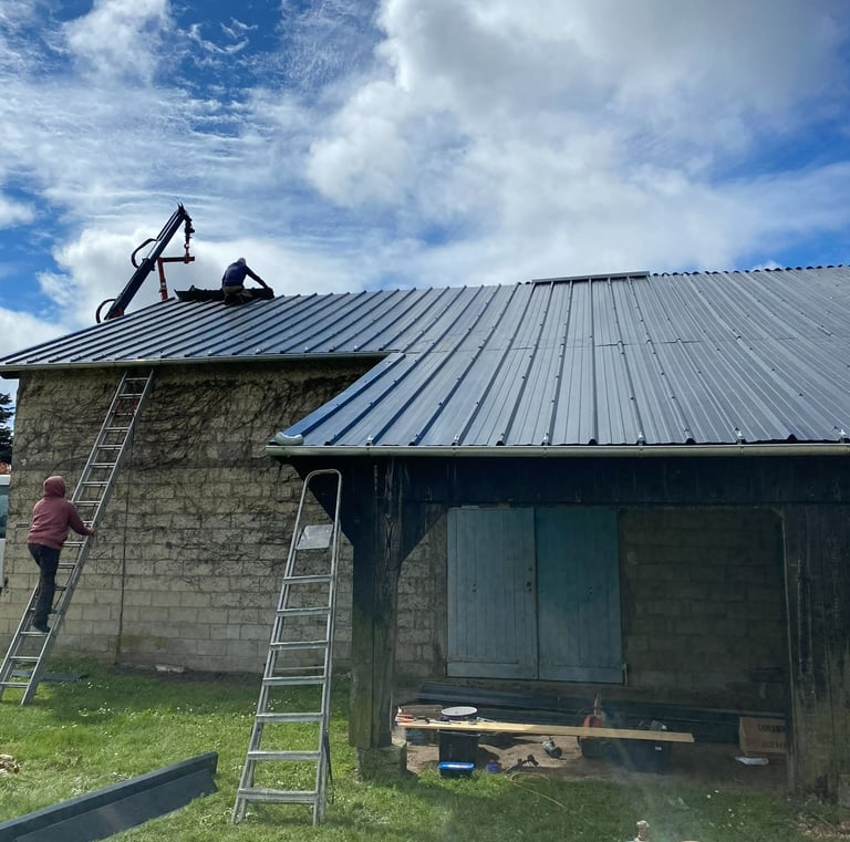 Des entrepreneurs professionnels installant un nouveau toit en métal à joint debout de couleur gris 