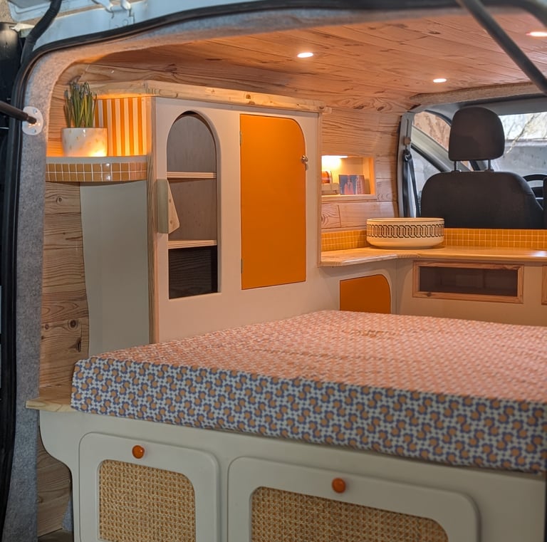 Intérieur van cosy avec éclairage chaleureux, mobilier en bois et rangements personnalisés Pinbeur.