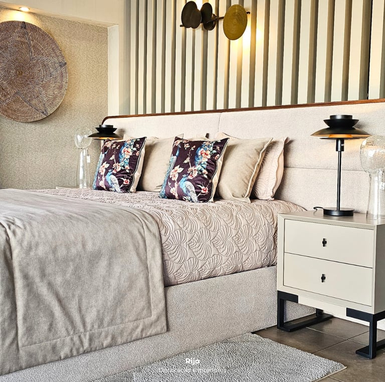 Modern luxury bedroom featuring a beige upholstered bed, floral pillows, and minimalist nightstands with elegant lighting.