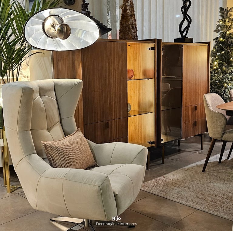 Modern living room furniture featuring a beige swivel armchair and a wood display cabinet with lighting.