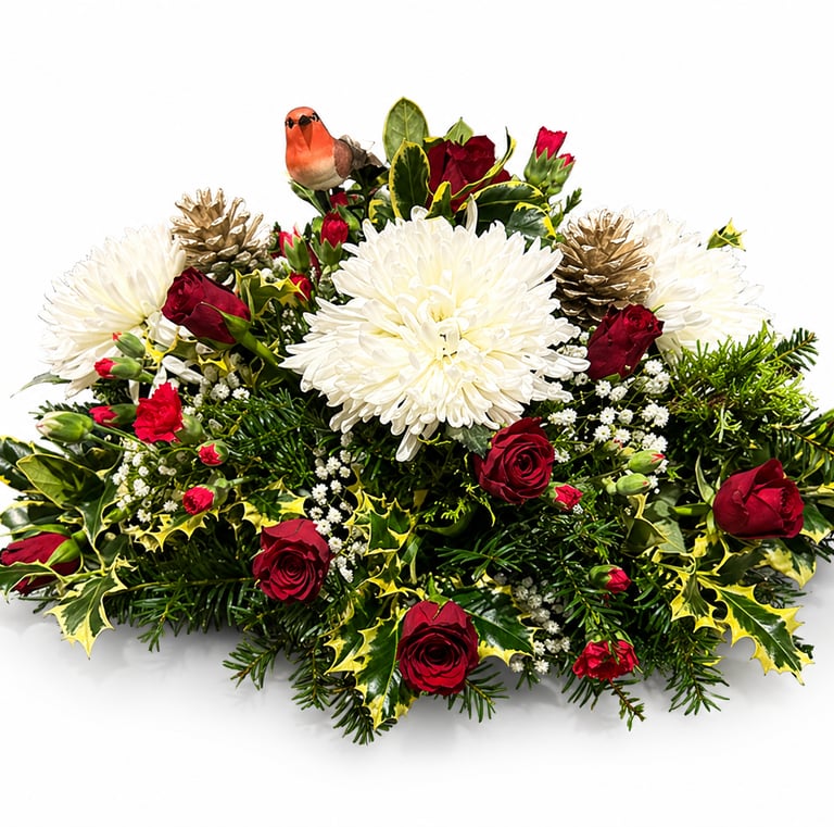 Christmas floral centerpiece with red roses, white chrysanthemums, holly, and a robin figurine.