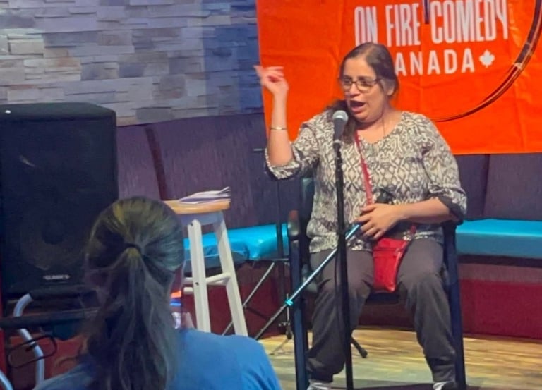 A female comedian performs a stand-up comedy set at On Fire Comedy Canada with a microphone.