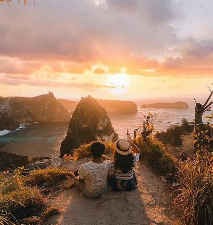 the sunsets in Nusa Penida are often experienced from high cliffs, providing a breathtaking, panoram