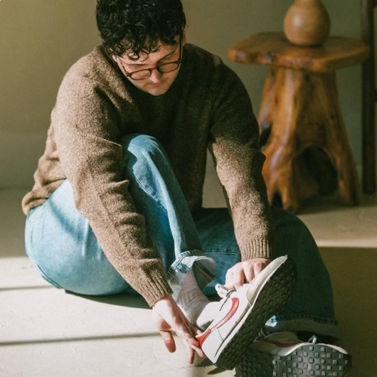 Dakota puting on his shoe in a casual setting
