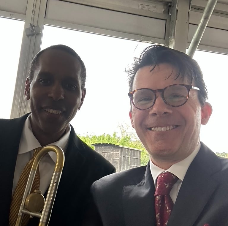 Trombonist Vincent Gardner and trumpeter George Chase smile for the camera at a performance.