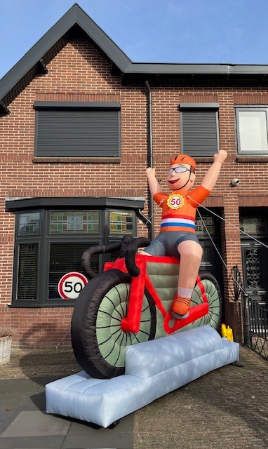 Oblaasbare wielrenner met oranje shirt en Nederlandse vlag zitten op een rode racefiets