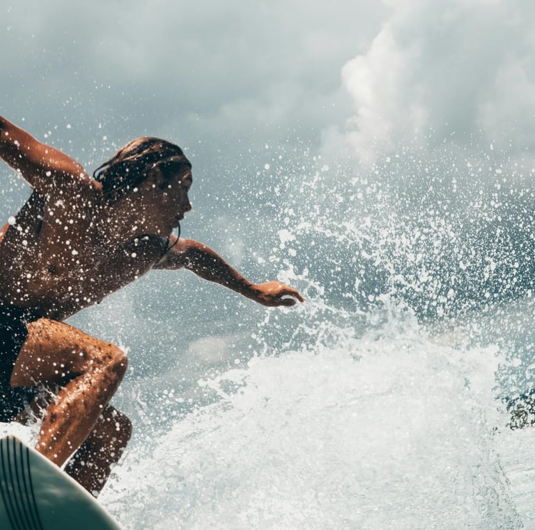a man with long hair riding a surfboard in the ocean