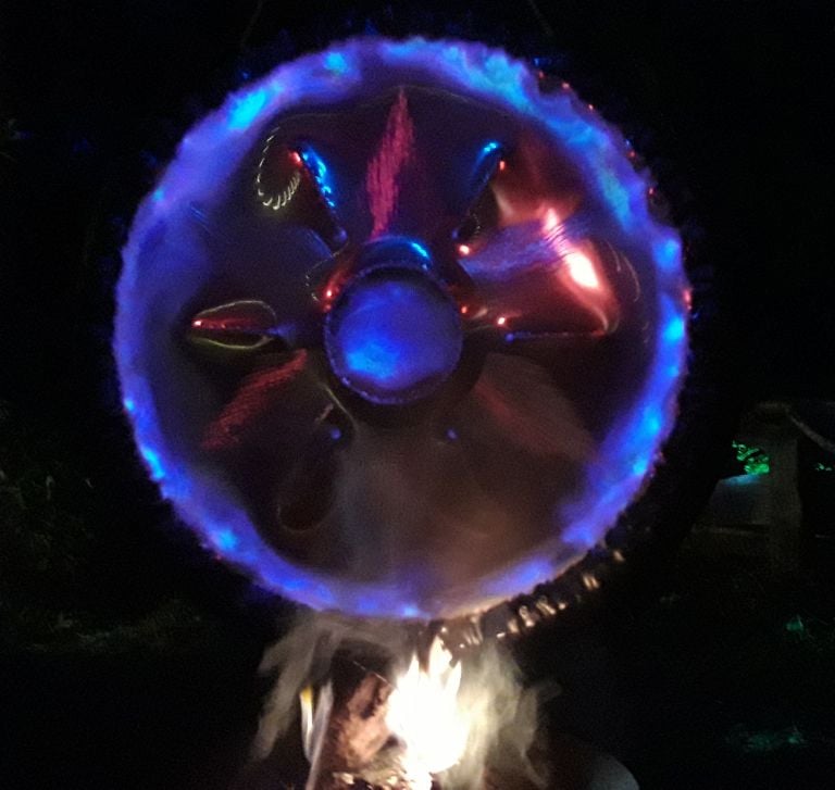 Gong im Lagerfeuer angestrahlt mit blauem Licht