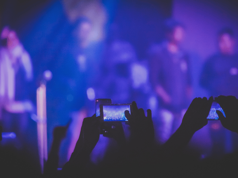 a person holding a cell phone in front of a stage