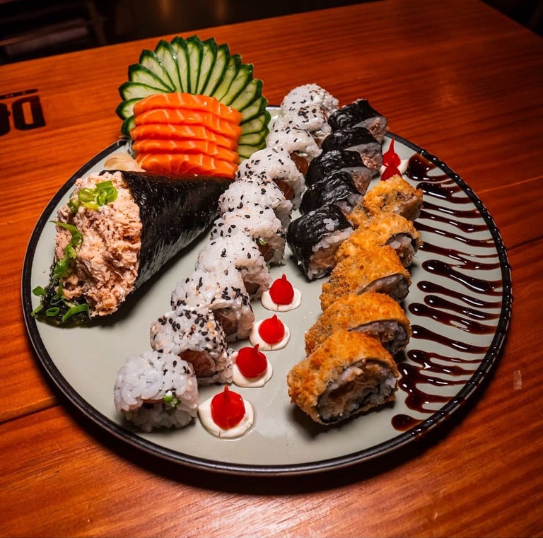 a plate of sushi rolls with sauce and sauce