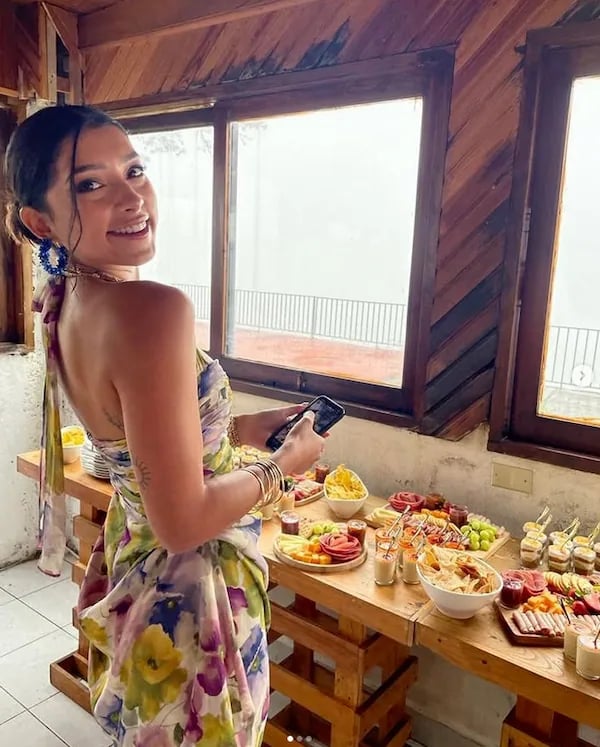 a woman in a dress standing in front of a table with food