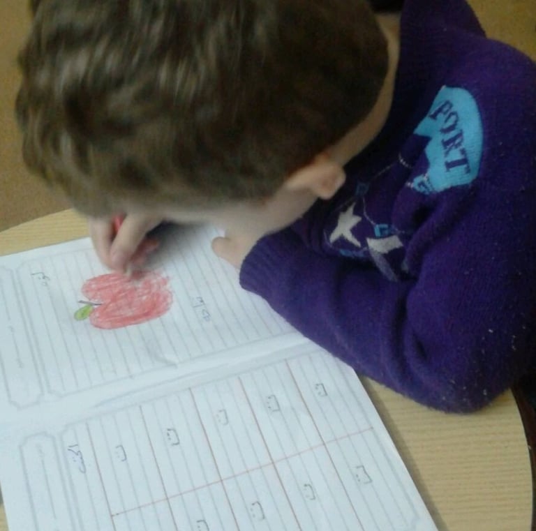a young boy is writing numbers on a paper