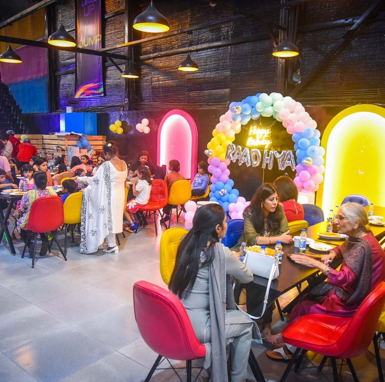 a group of people sitting at tables with balloons