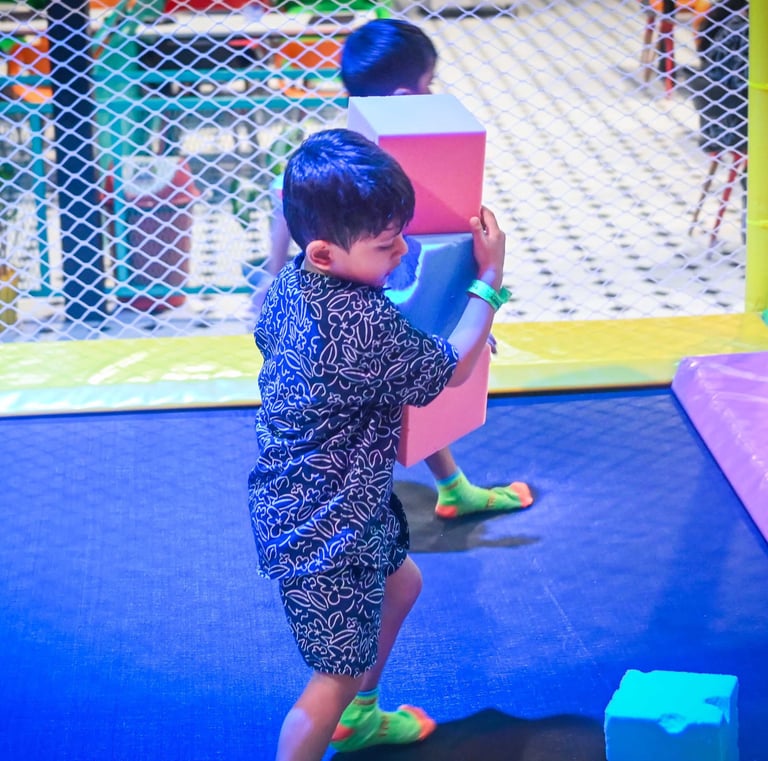 a young boy playing with blocks on a trampoline
