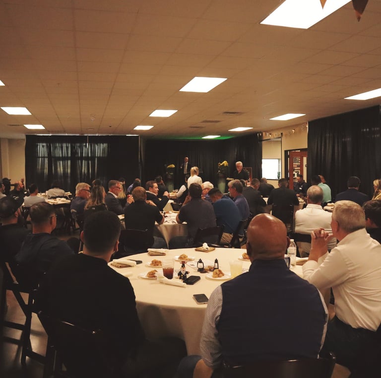 a group of people sitting at tables in a room for an event
