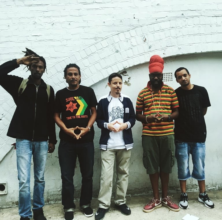 a group of men standing in front of a brick wall