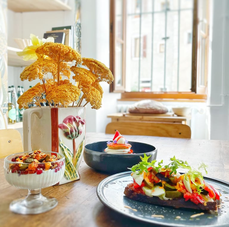 une table avec brunch en intérieur avec granulat aux fruits frais, pancakes et bruschetta