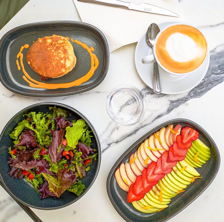 a table with a plate of food and a cup of coffee