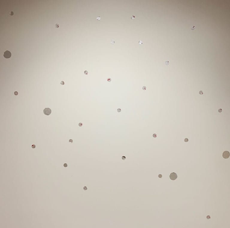 Fun yet elegant silver dot decals are spread over a white wall