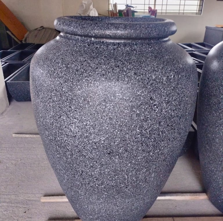 a group of three large vases with granited stone