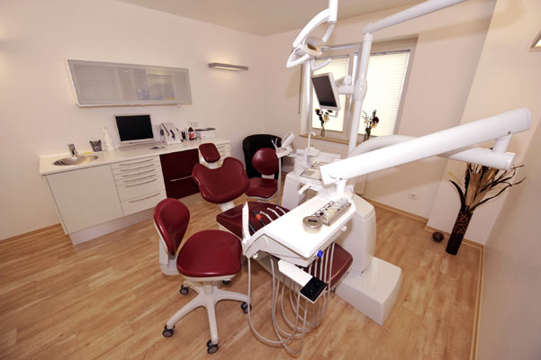 a dental room with a chair and a desk
