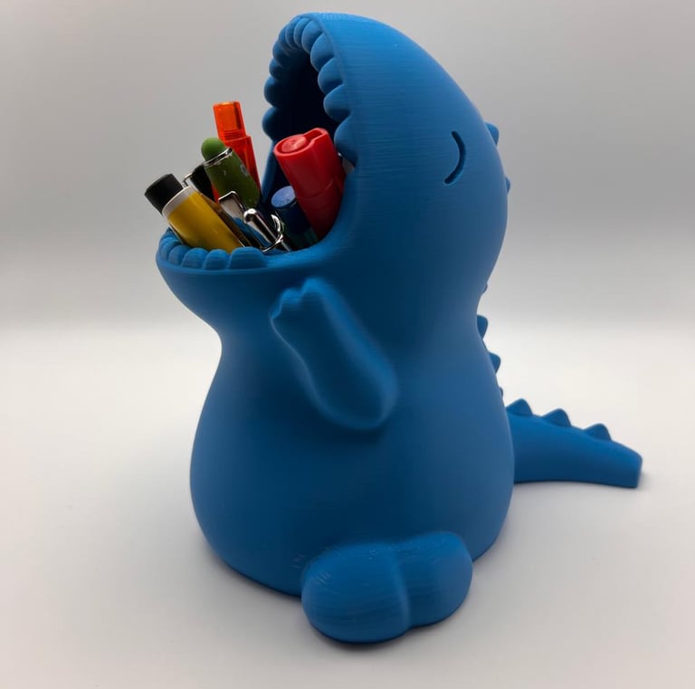 Blue 3D printed dinosaur pencil holder for desk organization featuring colorful pens in its mouth.