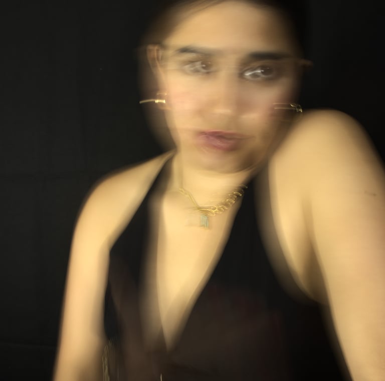 Retrato artístico con desenfoque de movimiento de una mujer con joyeria sobre un fondo oscuro