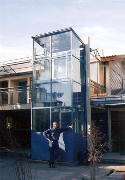 a man standing in front of a glass building