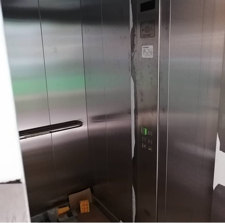 a metal elevator with a metal door and a box of boxes