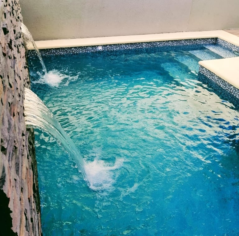 a pool with a waterfall and a waterfall