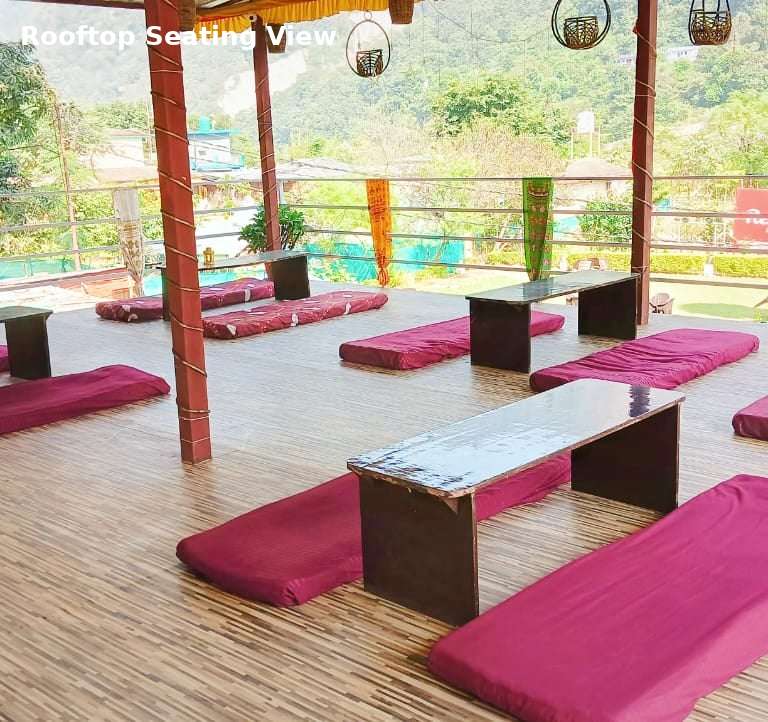 Rooftop seating area at Jungle Lore Resort with mountain view and floor seating