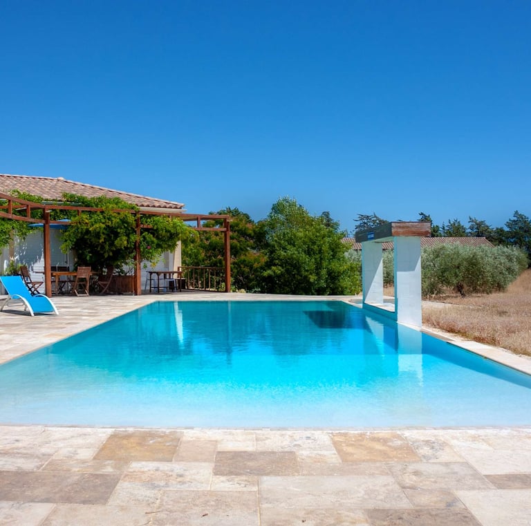 Swimming pool with beach chairs, wide view and waterfall, built-in cascade at Domaine Des Lucques