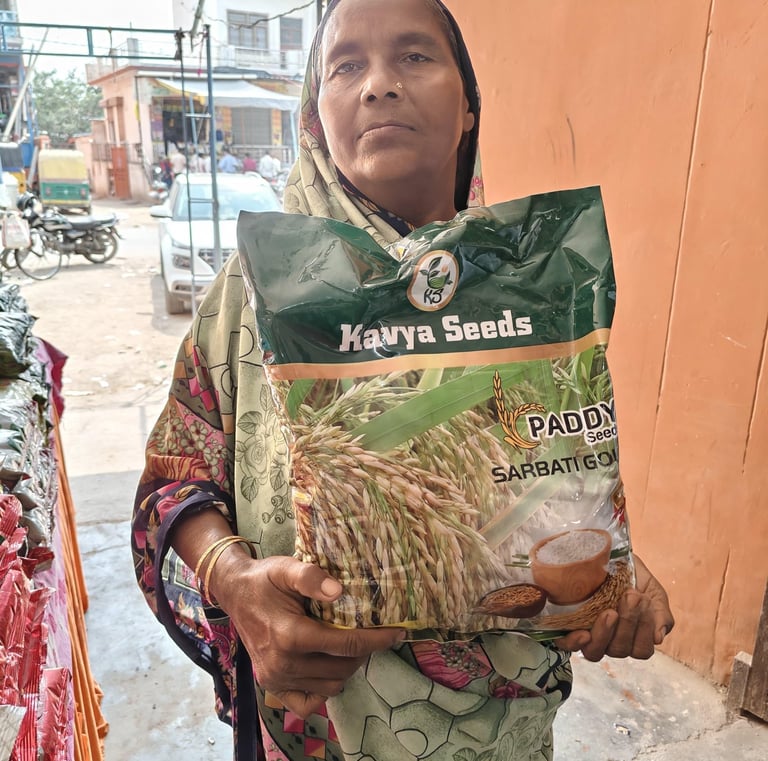 A woman holding a large bag of Kavya Seeds Sarbati Gold paddy seeds for agriculture.