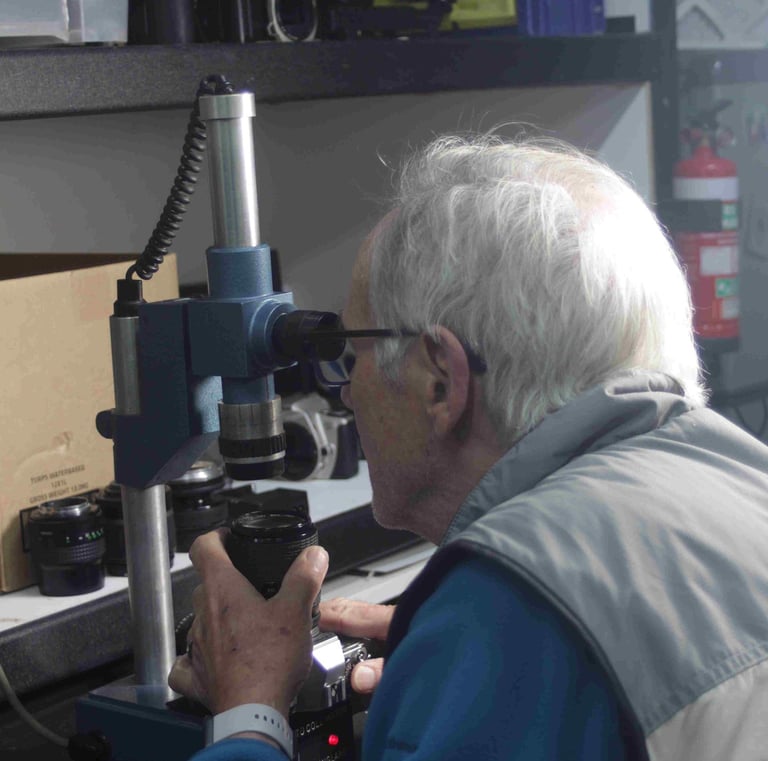 A technician carrying out focus adjustment and recollimation on a Canon camera