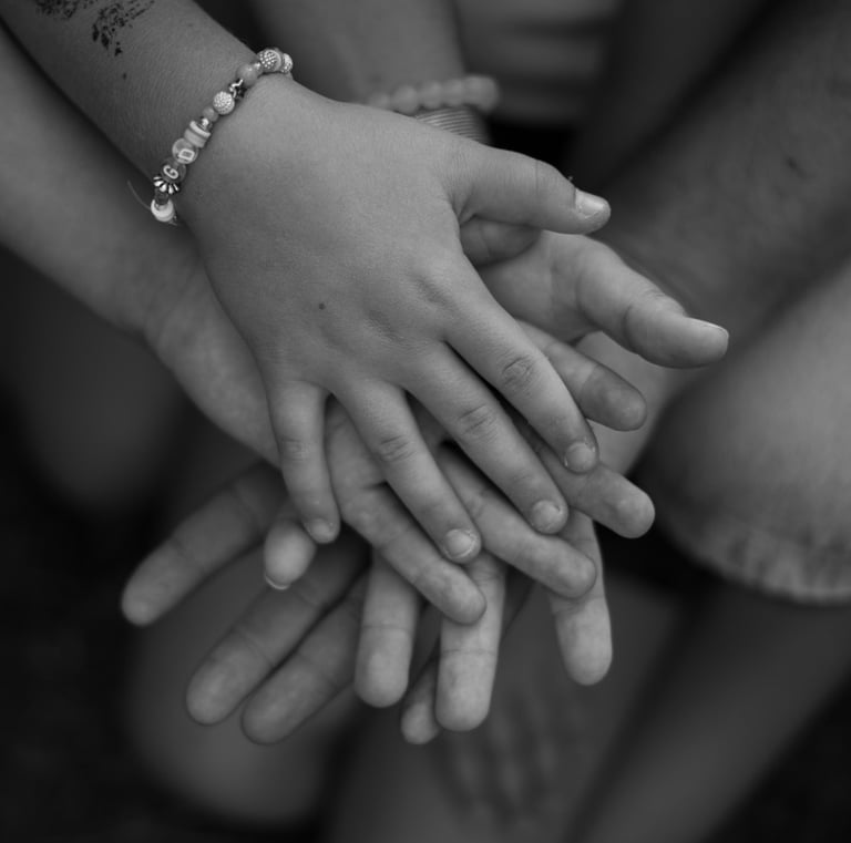 black and white image with hands piled on each other