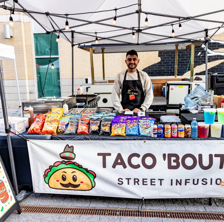 Street food vendor at Afro Fiesta Festival selling walking tacos and snacks under a white tent.