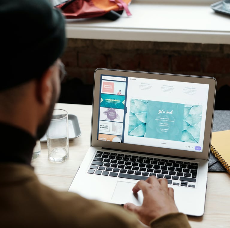 Black man with glasses review website design ideas on a laptop