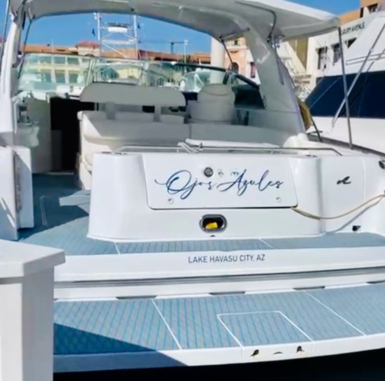 The stern of a white luxury motorboat named Ojos Azules docked at Lake Havasu City, Arizona.