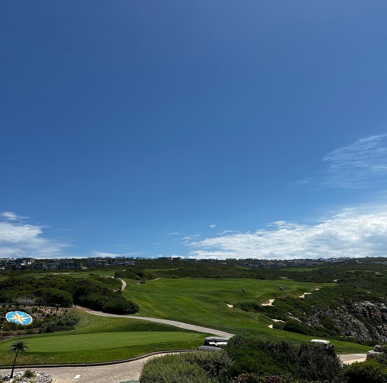 a golf course with a golf ball and a blue sky
