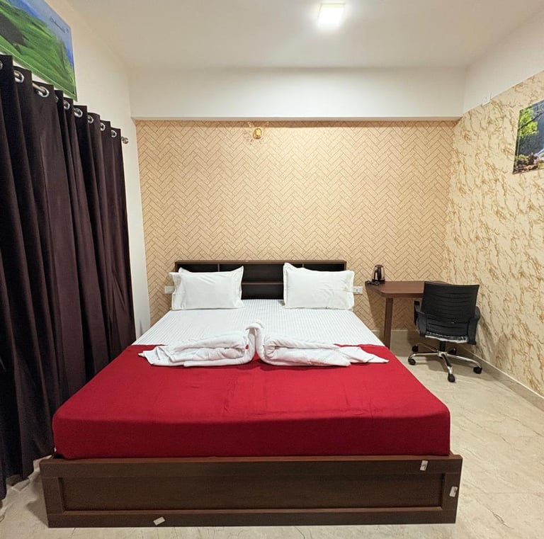 a bed with a red bed and a desk with a computer