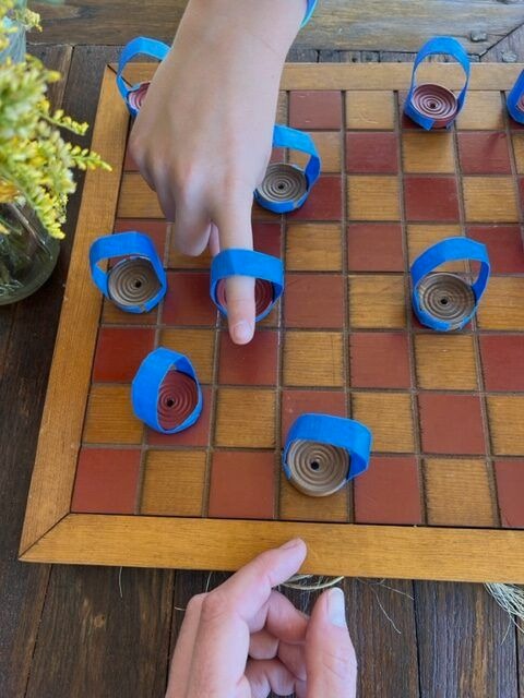 uma pessoa jogando damas em uma placa de madeira